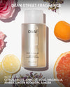 OUAI body cleanser bottle with fruits and flowers on a light background