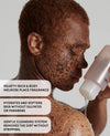 Close-up of a person with freckles holding and pouring a translucent cleansing bottle against a light gray background, with three text callouts on the left describing the fragrance and cleansing benefits.