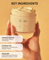 Jar of Quai body cream held by a hand with key ingredients listed on a yellow background