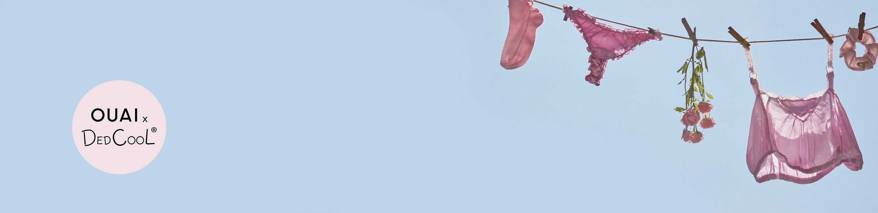 Pink lingerie hanging on a clothesline against a blue sky with 'OUAI' branding.