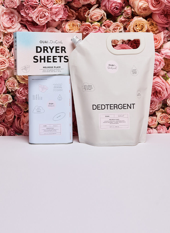 Two packages of 'OUAI' products against a pink rose background
