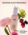 OUAI leave-in conditioner bottle with floral and fruit elements on a light pink background