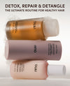 Three Ouai hair care bottles stacked vertically on a white background with decorative foam. The top bottle contains amber liquid and is labeled 'Detox Shampoo', the middle is a dusty mauve bottle labeled 'Bond Repair Mask', and the bottom is a pale peach bottle labeled 'Matte Finish'.