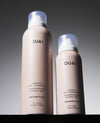 Two OUAI Super Dry Shampoo bottles shown side by side on a dark background