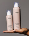 Two OUAI Super Dry Shampoo bottles shown side by side on a dark background