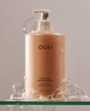 OUAI Thick Hair Shampoo 16oz pump bottle surrounded by soap bubbles
