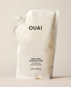 A white OUAI Fine Hair Conditioner refill pouch stands upright on a warm cream studio surface. Text: “OUAI”, “FINE HAIR”, “CHEVEUX FINS”, “CONDITIONER”, “REVITALISANT”, “32 fl oz / 946 ml”.