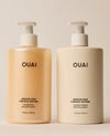 Two jumbo OUAI Medium Hair shampoo and conditioner pump bottles stand side by side, with amber-toned shampoo and cream conditioner packaging against a neutral studio background.