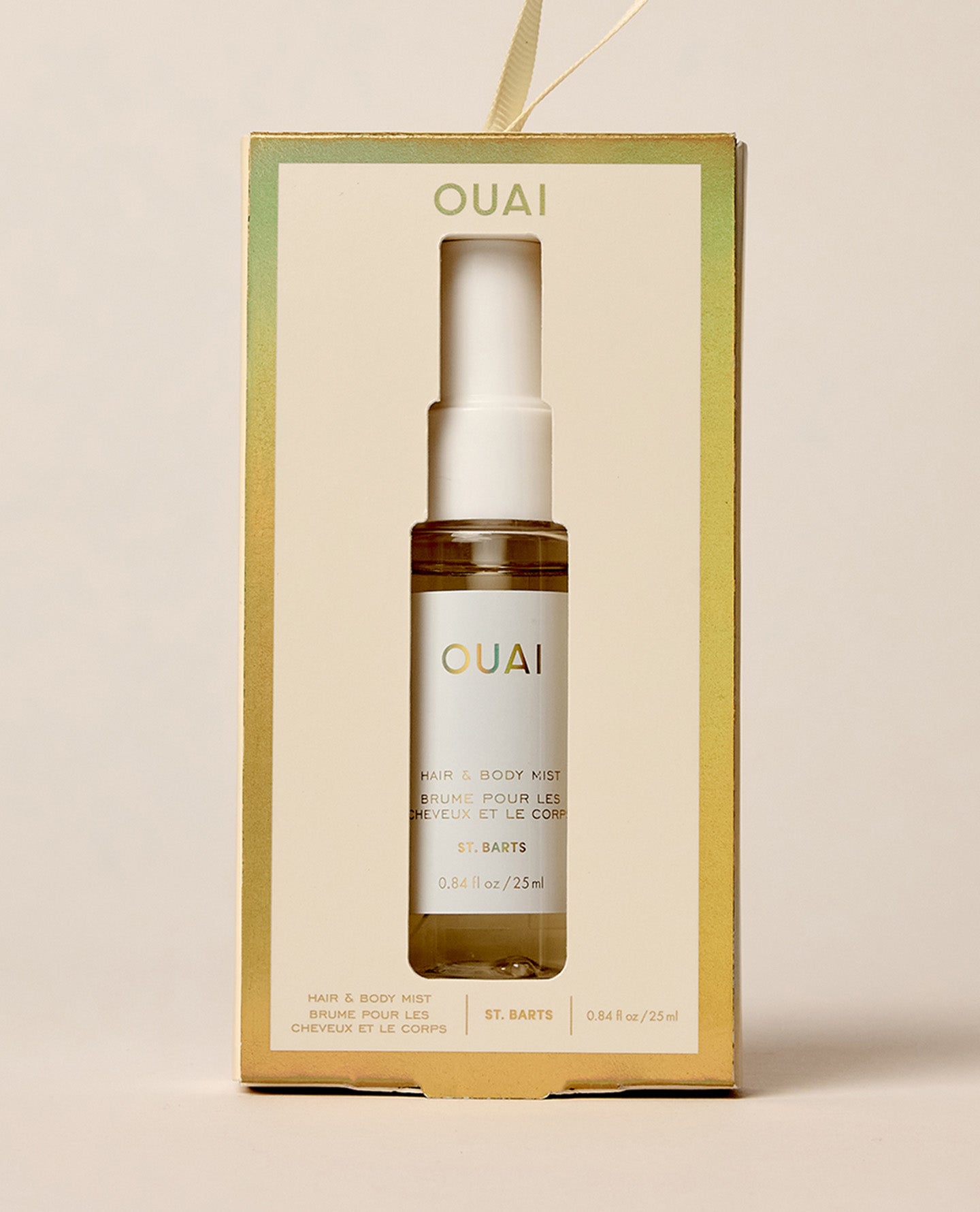 OUAI St. Bart's Hair & Body Mist in a clear glass spray bottle with a white pump, presented inside its cream-colored packaging box with gold borders.