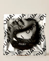 OUAI branded hair tie packaged in silver foil wrapper on neutral background.